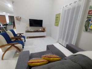 a living room with a couch and chairs and a tv at Lar das Cerejeiras in Bananeiras