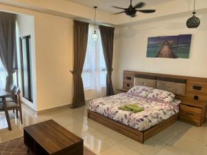 a bedroom with a bed and a table in it at Bali Residence Impian Raudah in Melaka