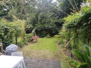 a small garden with a yard with grass and trees at Maison proche de tout in Saint-Herblain