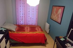 a bedroom with a bed with a red blanket at Maison proche de tout in Saint-Herblain