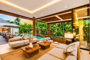 an open living room with white furniture and large windows at Madaharsa 4 BR Private Pool Villa ZN203 in Ubud