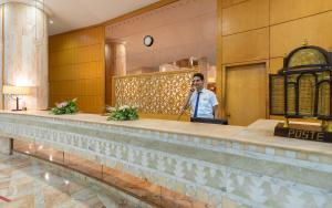 a man talking on a cell phone in a hotel lobby at Marhaba Royal Salem - Family Only in Sousse