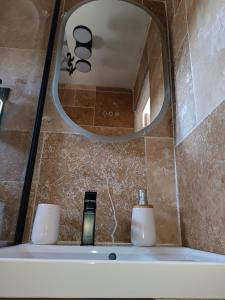 a bathroom sink with a mirror and two candles at Maison berrichonne WiFi jardin linge in Aigurande +59 photos