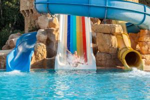 a child sliding down a water slide in a pool at Marhaba Royal Salem - Family Only in Sousse