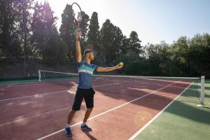 a man serving a tennis ball on a tennis court at Marhaba Royal Salem - Family Only in Sousse