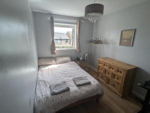 a bedroom with a bed with two towels on it at Tranquil 3-Bedroom Home in Edinburgh in Edinburgh