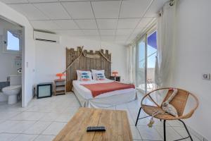 a bedroom with a bed and a table and a chair at Hotel Camille in Saintes-Maries-de-la-Mer