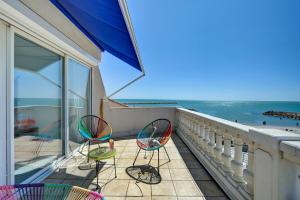 two chairs sitting on a balcony overlooking the ocean at Hotel Camille in Saintes-Maries-de-la-Mer