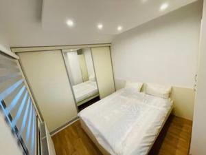 a small room with a bed and a mirror at Apartman Admir in Gladno Polje
