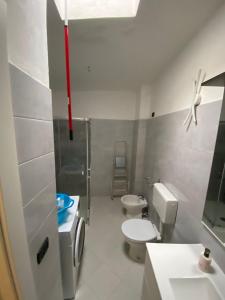 a bathroom with a toilet and a sink and a ladder at Casa Vittorio in Bari Sardo +3 photos
