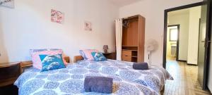 a bedroom with a blue and white bed with pillows at Maison "La Fleur d'oranger" climatisée, classée 3 étoiles, jardin clos, box internet in Saint-Féliu-dʼAmont