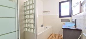 a white bathroom with a shower and a sink at Maison "La Fleur d'oranger" climatisée, classée 3 étoiles, jardin clos, box internet in Saint-Féliu-dʼAmont +32 photos