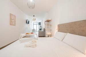 a white bedroom with a bed and a table at VisitVal Flats 3 in Valencia +17 photos