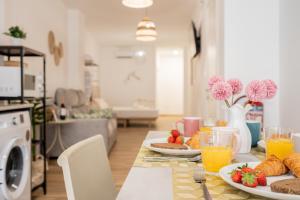 a table with plates of food and drinks in a living room at VisitVal Flats 3 in Valencia