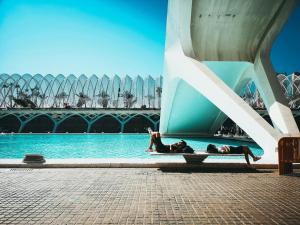 two people laying in the water next to a building at VisitVal Flats 3 in Valencia
