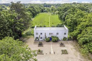 an aerial view of a white house in a field at A House in the Woods in Chiddingly