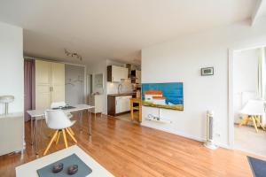 a living room with white walls and a wooden floor at Ferienwohnung Oberdeck in Schilksee