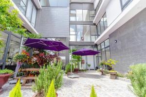 un patio con sombrillas moradas frente a un edificio en Mega Sky Dalat Hotel, en Da Lat 37 fotos más