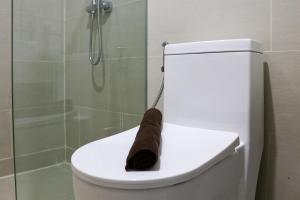 a roll of toilet paper sitting on top of a toilet at Comfort 2BR at Daan Mogot City Apartment By Travelio in Jakarta +12 photos