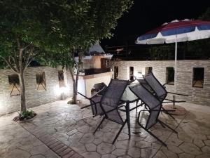a table and chairs with an umbrella on a patio at Panagio House in Pefki
