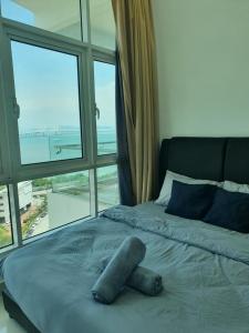 a bed in a room with a large window at Southbay Seaview Condo A2 10minQueensbay 10minSpice in Bayan Lepas +17 photos