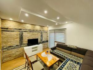 a living room with a couch and a table at Apartman Admir in Gladno Polje