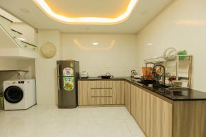 a kitchen with a refrigerator and a washer at Mai An Home in Da Lat