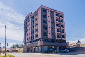 a pink building with cars parked in front of it at Naanyu Homestays in Nanyuki