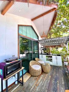 eine Terrasse mit einem Grill und Stühlen auf einer Holzterrasse in der Unterkunft Tropical Crystal Villa with Terrace Kitchen in Ko Phangan