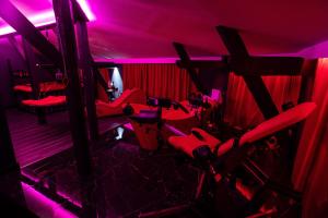 a room with red lighting and red chairs in it at Red Palace Apartament BDSM in Bydgoszcz