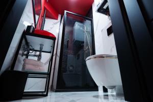 a bathroom with a shower and a toilet and a tub at Red Palace Apartament BDSM in Bydgoszcz