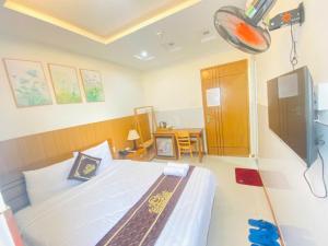 a bedroom with a bed and a room with a desk at KHÁCH SẠN PHÚ HƯNG in Ho Chi Minh City