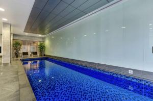 a swimming pool with blue water in a building at Swainson on Balfours in Adelaide