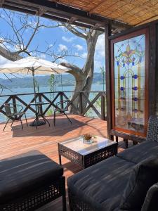 a patio with a couch and a table and a stained glass window at 長崎の波音で目覚める冒険基地 Villa 魔女の休日,Villa Witch's Holiday in Shirahama +13 photos