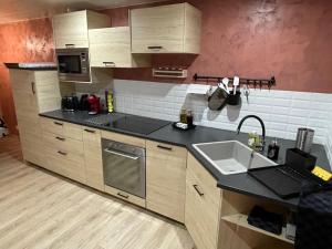 eine Küche mit Spüle und Arbeitsplatte in der Unterkunft Charme et quiétude au cœur du Haut-Jura in Lamoura