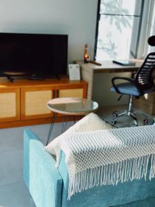 ein Wohnzimmer mit einem blauen Sofa und einem Tisch in der Unterkunft Tropical Crystal Villa with Terrace Kitchen in Ko Phangan