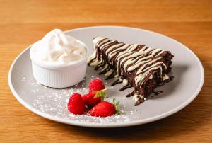a plate with a piece of chocolate cake and strawberries at The Kellbank in Gosforth