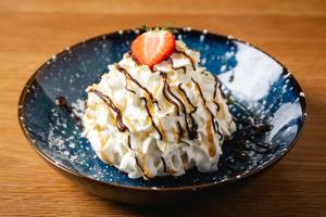 a dessert with a strawberry on a blue plate at The Kellbank in Gosforth