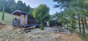 a wooden cabin with a table and a picnic table at Aurel inattendu in Aurel