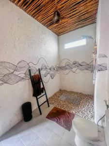 a room with a bathroom with a toilet and a window at Air Svarga Villa - Luxe Designer Villa Canggu in Canggu