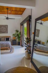 a mirror in a room with a bed and a couch at Air Svarga Villa - Luxe Designer Villa Canggu in Canggu