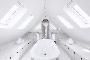 a white bathroom with a clock tower in the background at L'Agapa Hôtel - Spa Codage in Perros-Guirec