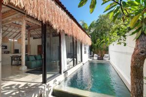 a house with a swimming pool next to a building at Villa Maison Pastis Canggu in Canggu