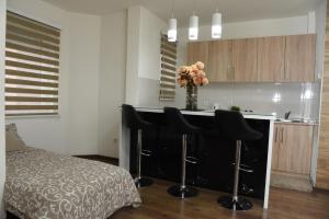 una cucina con bancone, sgabelli neri e tavolo di Apartmani Sofronic Loznica 2 a Loznica