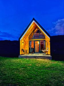 a small wooden house on a field at night at Eternum Glamping in Žabljak