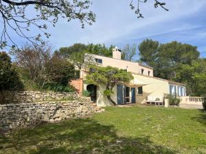 une ancienne maison en pierre avec un mur en pierre dans l'établissement Grand Lodge, à Pierrevert