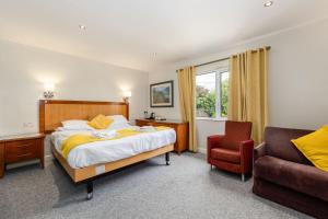 a hotel room with a bed and a chair at The Kellbank in Gosforth
