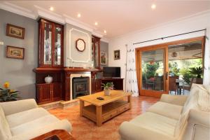Una sala de estar con chimenea y una mesa. en Villa Can Josep - Maldonado, en Pollensa