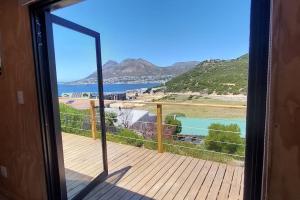 a door to a balcony with a view of the ocean at Quaint Cottage With Harbour Views in Cape Town