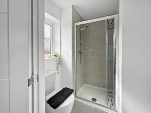 a white bathroom with a shower and a toilet at Amaya Seven - Luxury 3 bedroom detached house with garden & driveway - Sleeps 7 - Bottesford, Leicestershire in Bottesford +25 photos